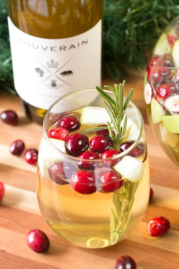 Christmas Sangria garnished with apple, rosemary, and cranberries
