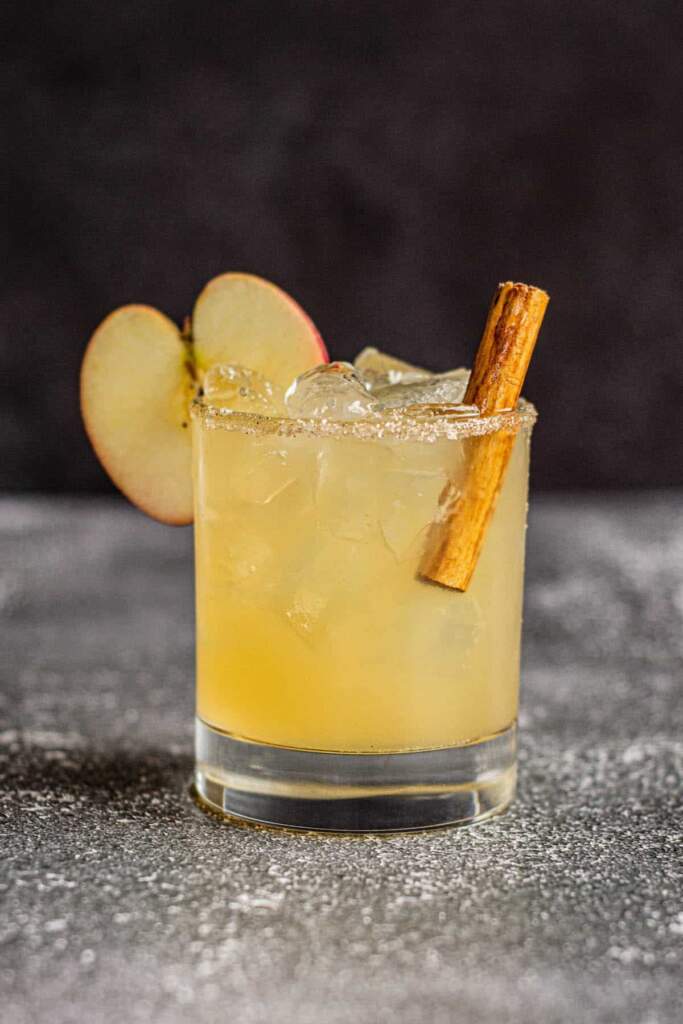 Glass of Bourbon Apple Cocktail with an apple slice and cinnamon stick
