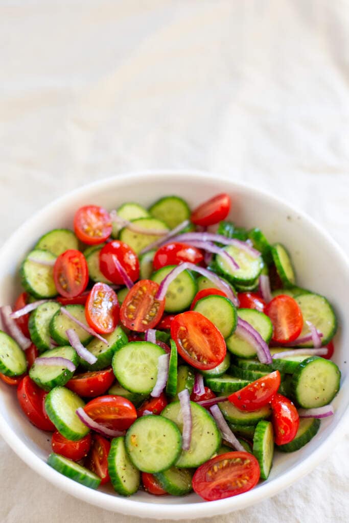 cucumber salad in a white bowl